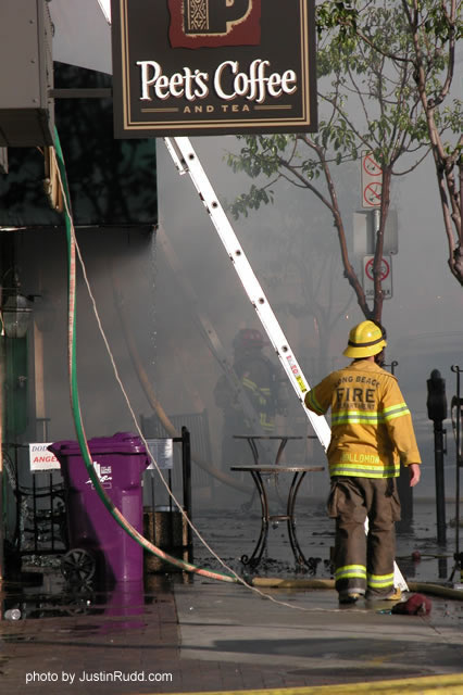 Firefighter Hollomon with the Long Beach Fire Department heads for a ladder to access the roof of the Bar & Grill.