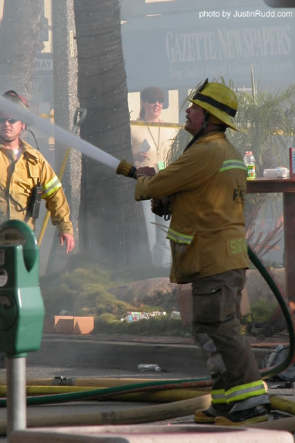 Holding the heavy hose across the street from the Grunion Gazette newspaper offices (in background).