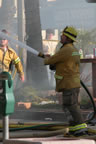 Holding the heavy hose across the street from the Grunion Gazette newspaper offices (in background). (49kb)